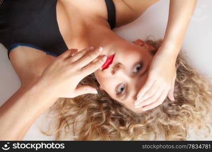 Portrait of beautiful sexy blonde girl lying on floor. Studio shot. Fashion and female beauty.