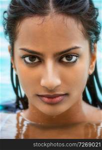 Portrait of beautiful sexy young Indian Asian woman or girl wearing bikini in swimming pool