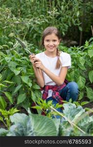 Portrait of beautiful smiling teenage girl working at garden
