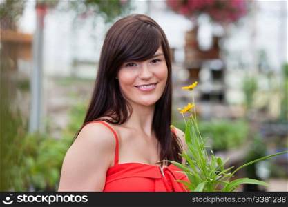 Portrait of beautiful smiling woman holding flower pot