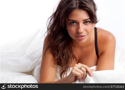 portrait of beautiful smiling young woman lying in bed in her underwear.