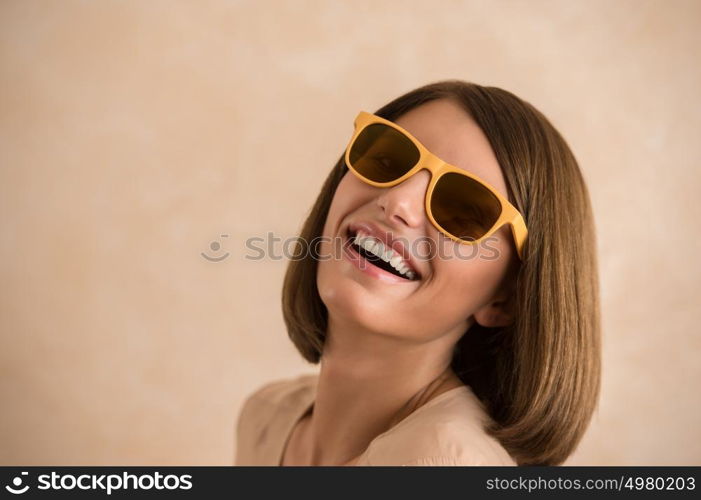 Portrait of beautiful smiling young woman wearing sunglasses