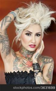Portrait of beautiful tattooed woman with hand in hair