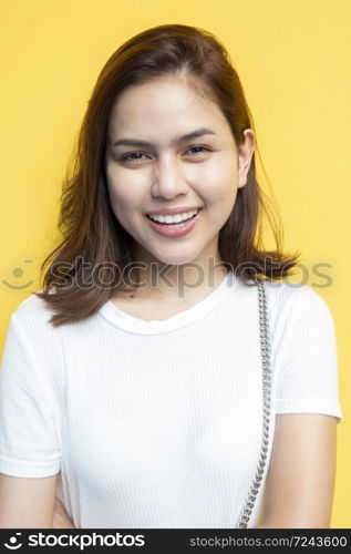 portrait of beautiful university student are smiling on yellow wall background