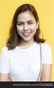 portrait of beautiful university student are smiling on yellow wall background