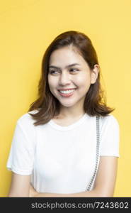 portrait of beautiful university student is smiling on yellow wall background