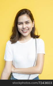 portrait of beautiful university student is smiling on yellow wall background