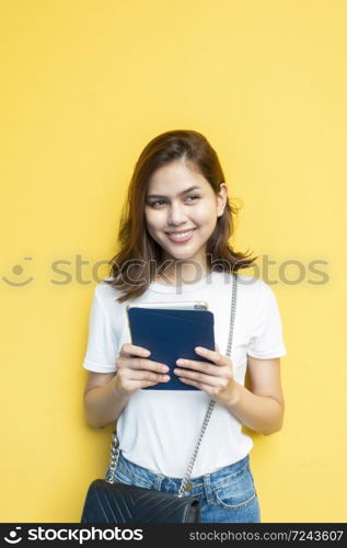 portrait of beautiful university student is smiling on yellow wall background