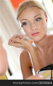 Portrait of beautiful woman applying eyeshadow