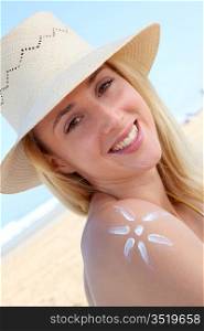 Portrait of beautiful woman applying sunblock on her skin