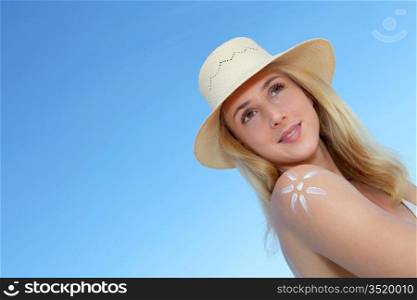 Portrait of beautiful woman applying sunblock on her skin