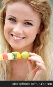 Portrait of beautiful woman eating fresh exotic fruits