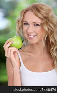 Portrait of beautiful woman eating green apple