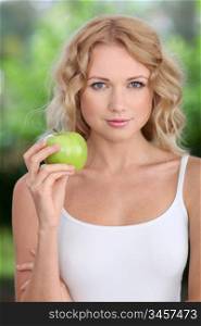 Portrait of beautiful woman eating green apple