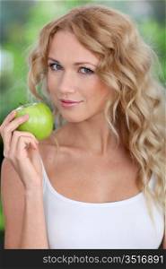 Portrait of beautiful woman eating green apple