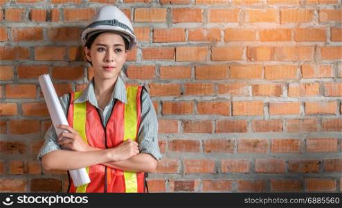 portrait of beautiful woman engineer in front of brick wall with copy space