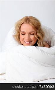 Portrait of beautiful woman in bed under blanket