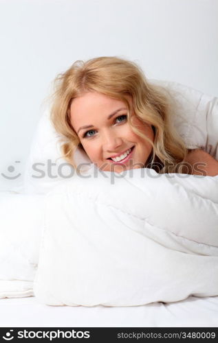 Portrait of beautiful woman in bed under blanket