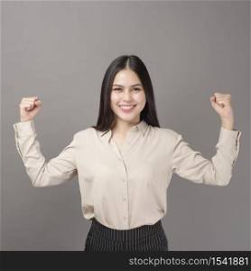 portrait of beautiful woman is happy with business successful on gray background