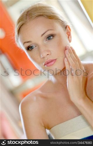 Portrait of beautiful woman looking at a mirror