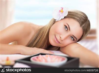 Portrait of beautiful woman lying down on massage table in spa salon, enjoying peace and relaxation, healthy lifestyle