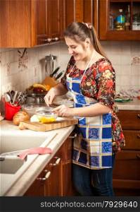 Portrait of beautiful woman mixing yolk on kitchen