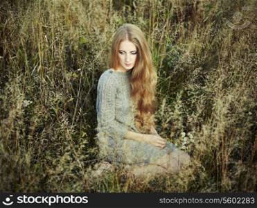 Portrait of beautiful woman on autumn field. Fashion photo