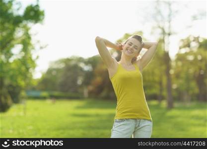 Portrait of beautiful woman relaxing in park|flare