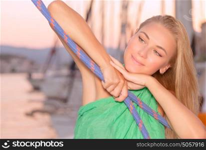 Portrait of beautiful woman relaxing on the sail boat, enjoying warm evening in the sea, luxury summer vacation, active lifestyle concept