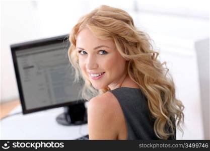 Portrait of beautiful woman sitting in front of desktop computer