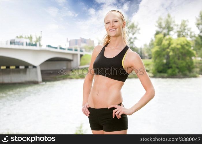 Portrait of beautiful woman smiling and posing against bridge