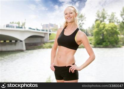 Portrait of beautiful woman smiling and posing against bridge