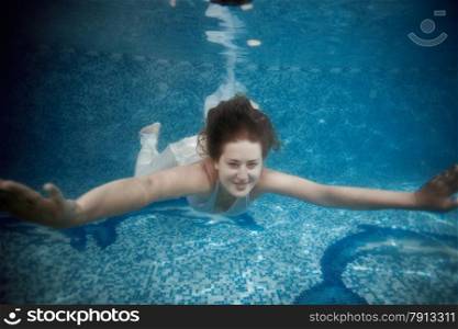 Portrait of beautiful woman swimming underwater at pool