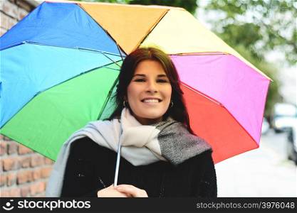 Portrait of beautiful woman under rainbow umbrella. Outdoors