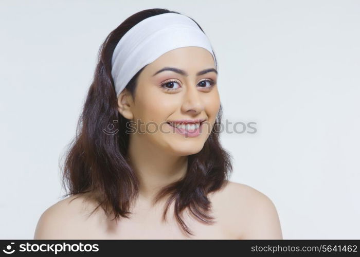 Portrait of beautiful woman wearing headband against white background