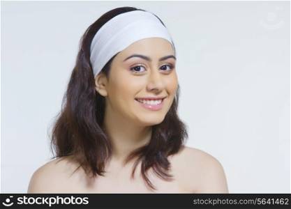 Portrait of beautiful woman wearing headband against white background