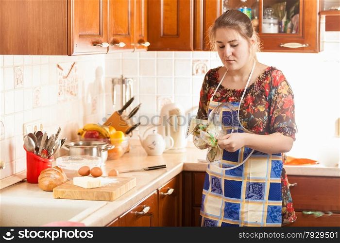 Portrait of beautiful woman wiping wet bowl with cloth