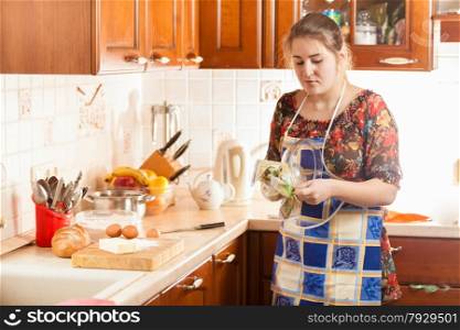 Portrait of beautiful woman wiping wet bowl with cloth