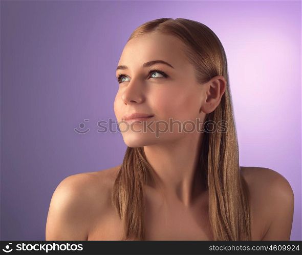 Portrait of beautiful woman with natural makeup looking up over purple background, perfect clear skin, beauty treatment concept
