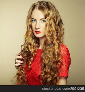 Portrait of beautiful woman with red hair in red dress. Fashion photo