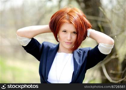 Portrait of beautiful woman with red hair posing outdoors