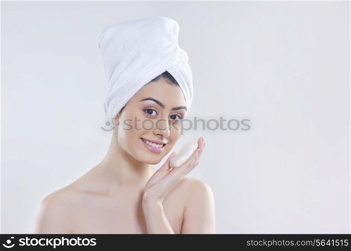 Portrait of beautiful woman with soap against gray background