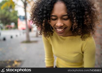 Portrait of beautiful young afro-american confident woman laughing in the street. Outdoors.