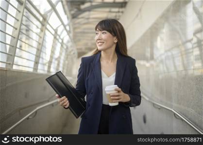Portrait of beautiful young asian business woman is working in modern city