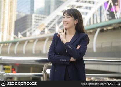 Portrait of beautiful young asian business woman is working in modern city