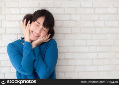 Portrait of beautiful young asian woman enjoy and happiness standing on gray cement texture grunge wall brick background, girl is a smiling and cheerful on concrete.