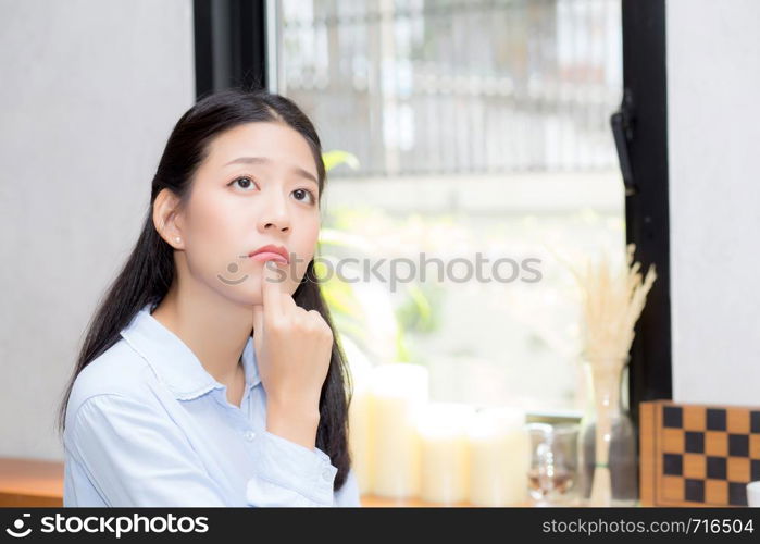Portrait of beautiful young asian woman happiness and think sitting at cafe shop, businesswoman is a smile, freelance people concept.