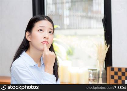 Portrait of beautiful young asian woman happiness and think sitting at cafe shop, businesswoman is a smile, freelance people concept.