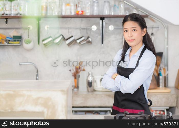 Portrait of beautiful young barista, asian woman is a employee standing in counter coffee shop, service concept.