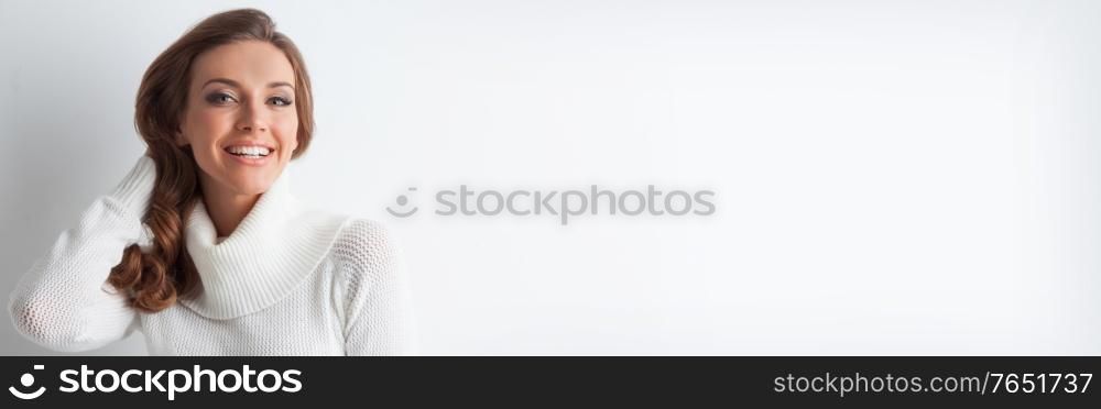 Portrait of beautiful young blonde caucasian woman with flawless skin and perfect make-up in winter white knitted pullover. Portrait of woman in knitted pullover